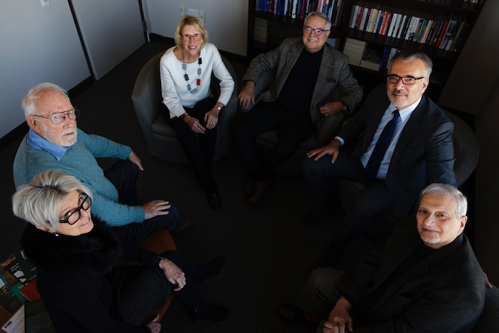 Sara Cobb, Chris Mitchell, Sandra Cheldelin, Rich Rubenstein, Alpaslan Ozerdem, and Kevin Avruch sit together in the office of the dean at the Carter School in Arlington, Virginia.