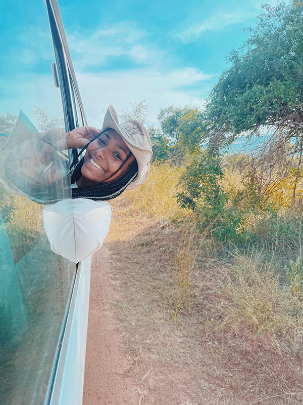 Student smiling and leaning out of a vehicle window in Rwanda
