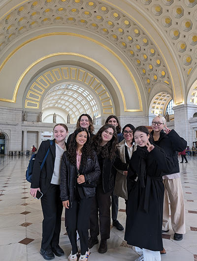 Students in a group, smiling inside of a domed building